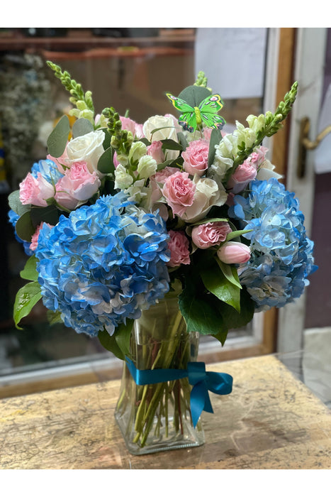 Luxurious flower arrangement featuring blue hydrangeas, roses, and snapdragons, perfect for celebrations, home decor, or gifts. Crafted in Brooklyn, NY.