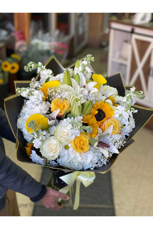 Bright and elegant bouquet with sunflowers, white roses, white hydrangeas, and lilies, handcrafted by a Brooklyn florist. Perfect for any occasion.