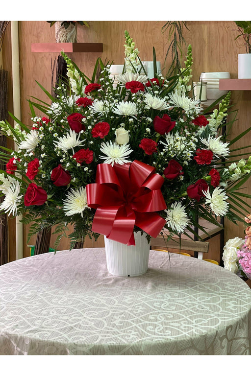 Elegant rose floor basket with fresh roses, arranged for sympathy or funeral service, created by Brooklyn flower shop.